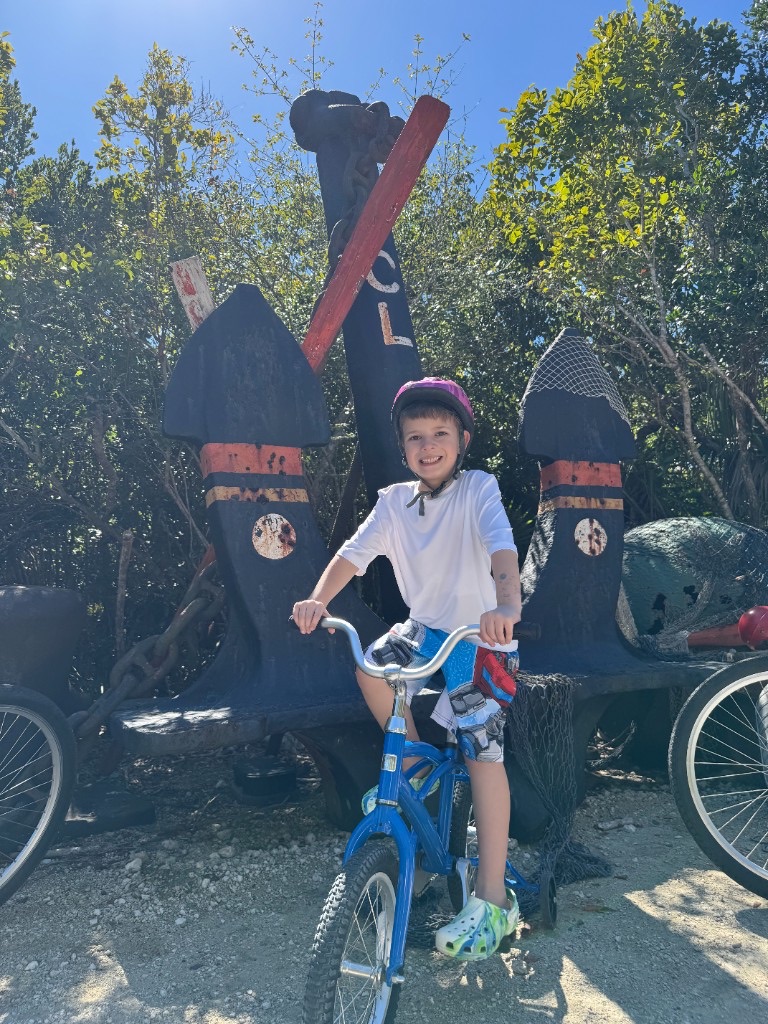 Child on a bike by the Castaway Cay DCL anchor